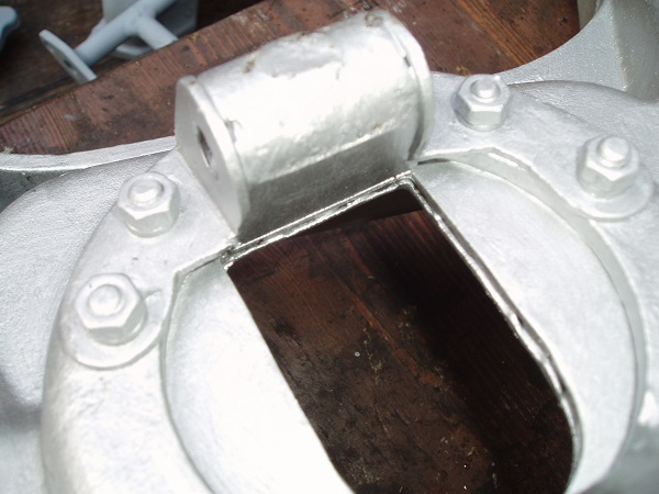 Two 'L' brackets supporting the main through bolt, connected through trailing arm by 4 stainless screws.
