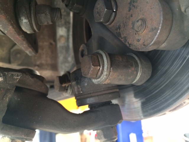 between lower ball joint and vertcal link.  Extra washer to compensate for longer bolt